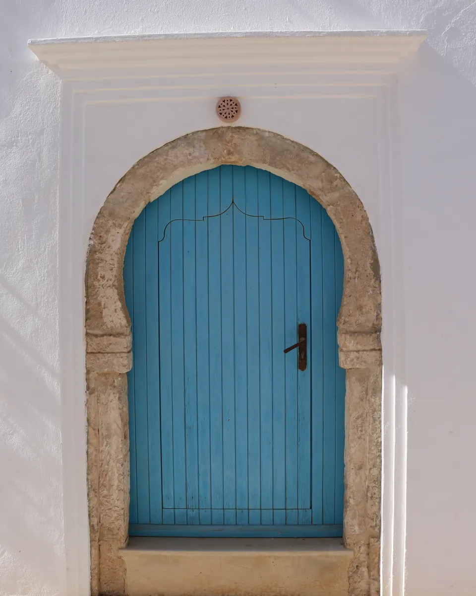 Porte bleue traditionnelle dans un mur blanchi à la chaux, à Djerba